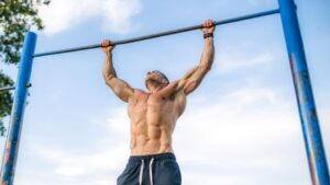 Allenamento streetlifting di un uomo con trazioni alla sbarra