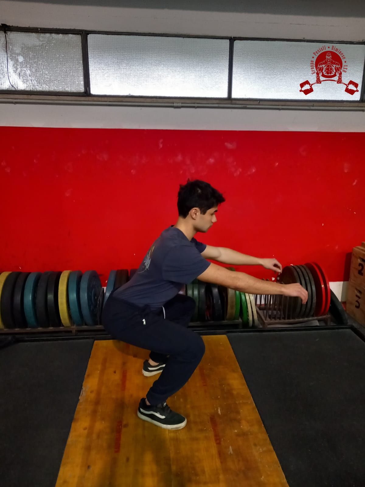 Atleta che esegue un air squat in palestra