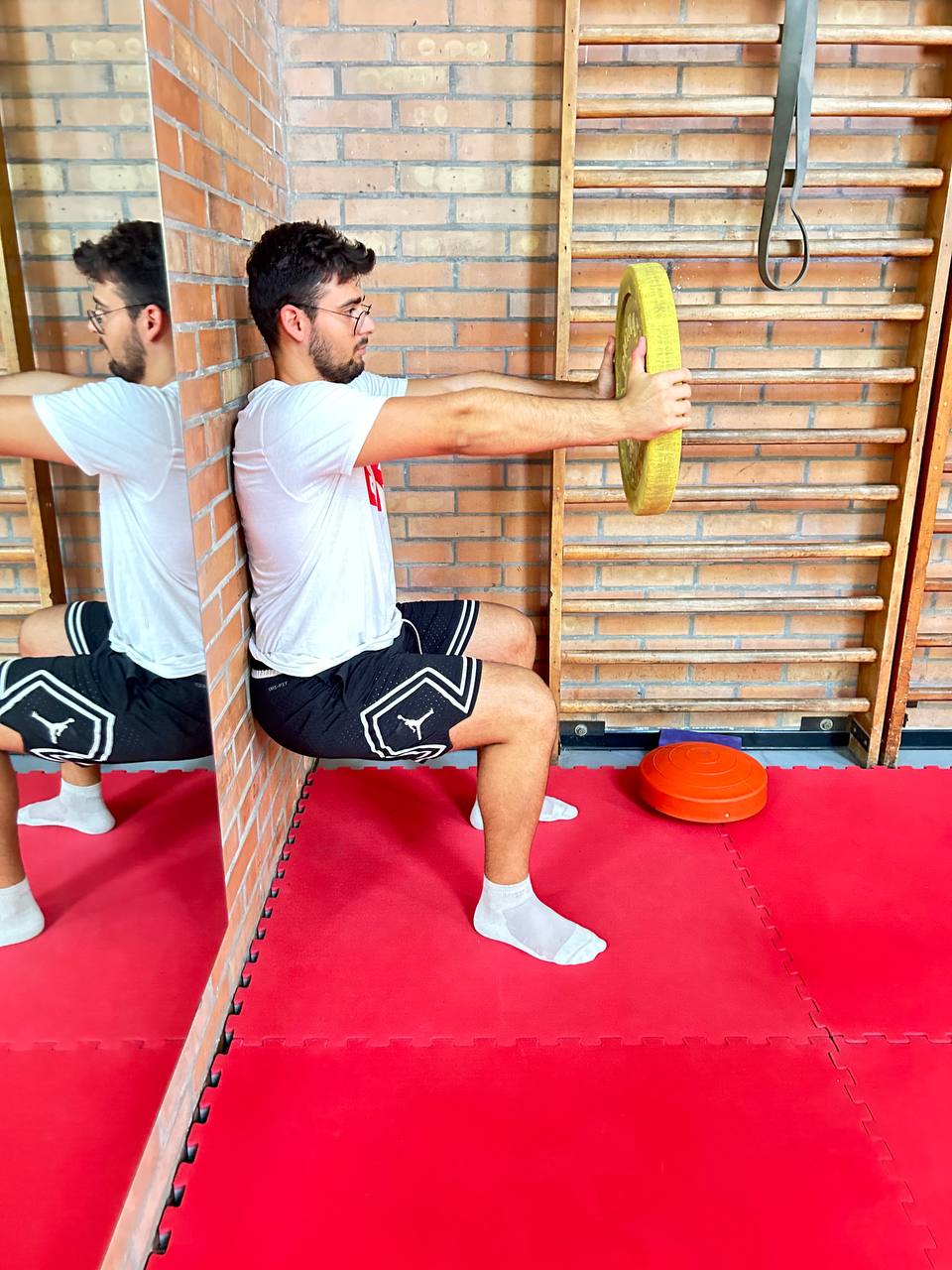 Atleta che esegue il Wall Sit in palestra
