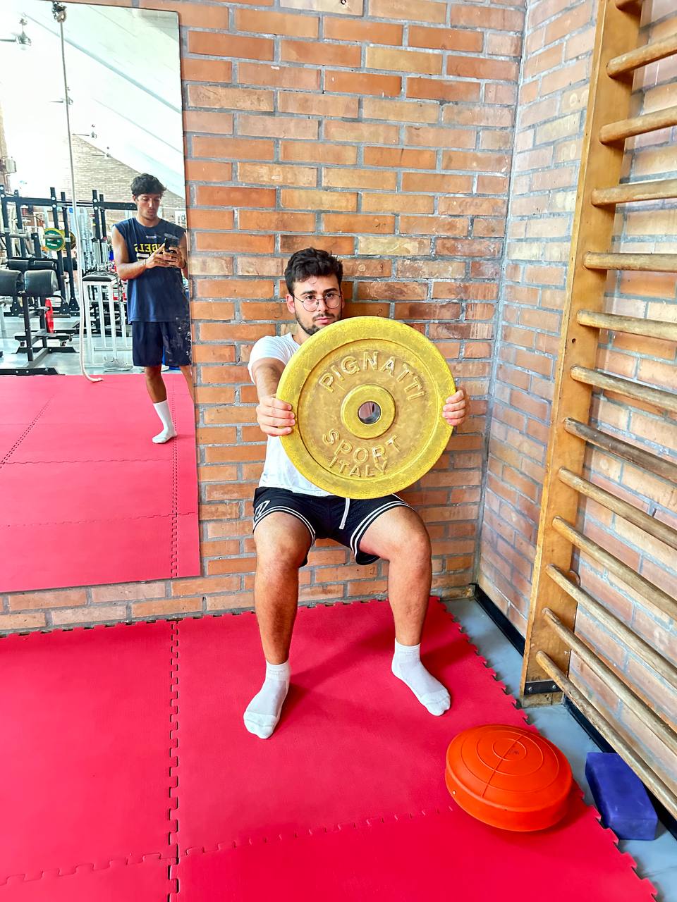 Atleta che esegue il Wall Sit con un peso